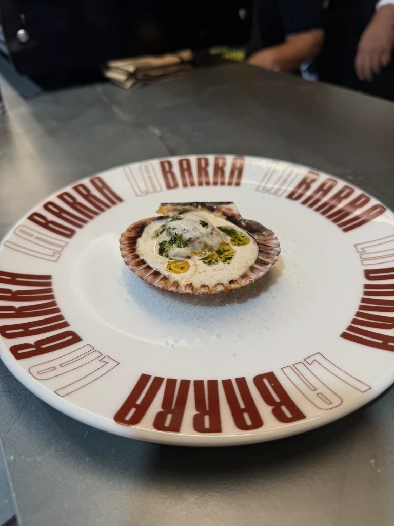 Zamburiña a la plancha con salsa de avellanas tostadas, leche de coco y brotes de hierbas de caracol